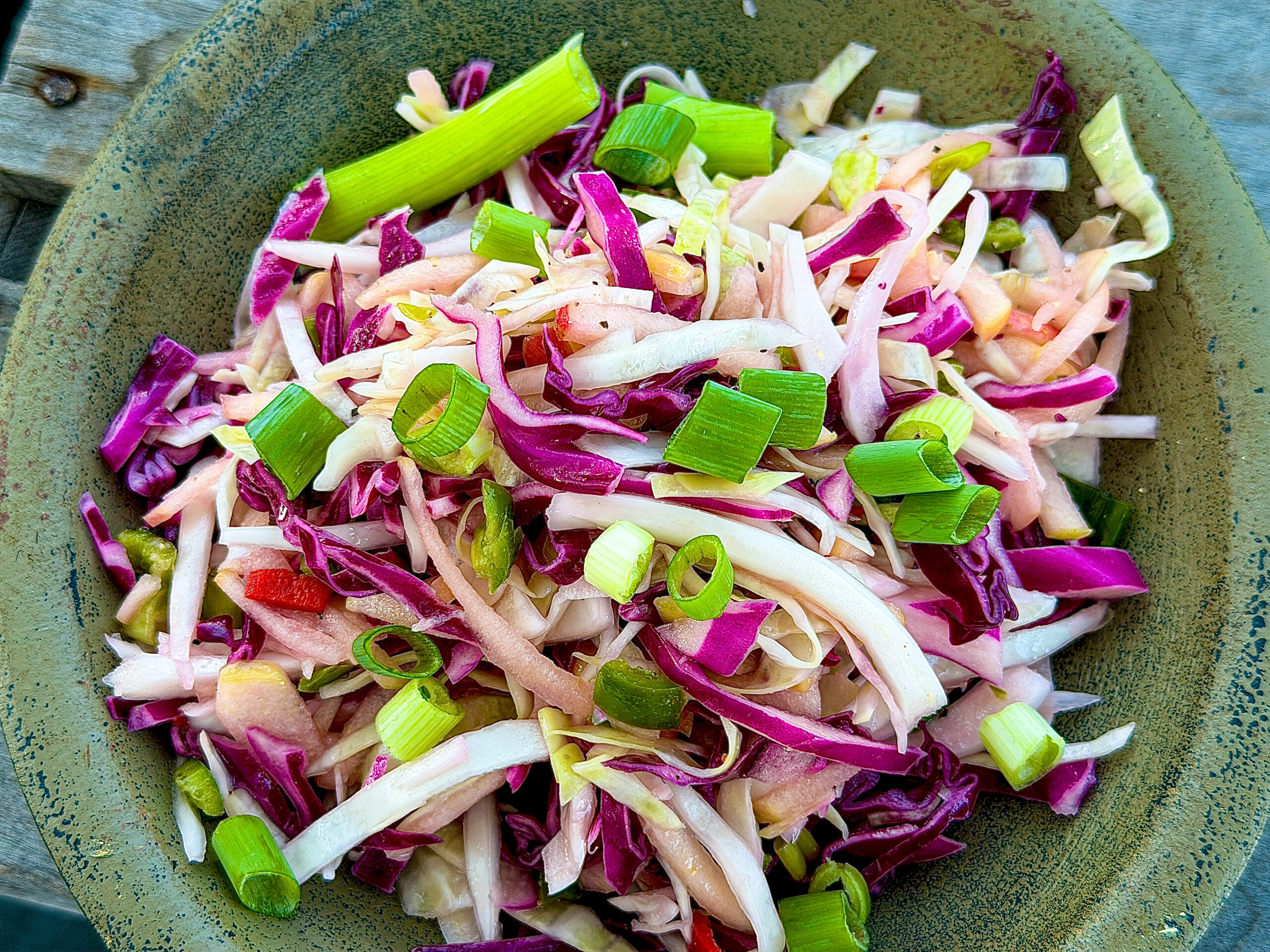 green wood bowl with mixed vegetable slaw