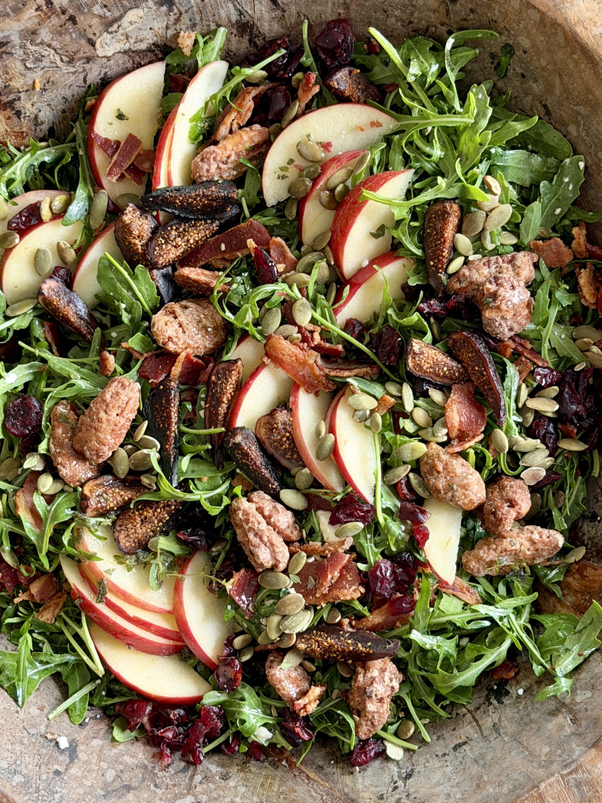 Honeycrisp Apple Salad with bacon, arugula, pumpkin seeds, and candied pecans in wood bowl